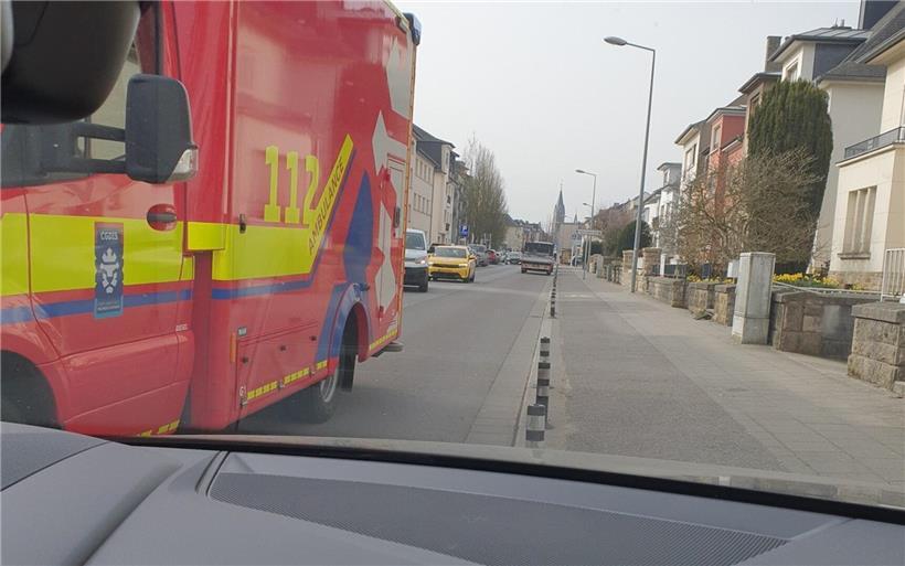 Krankenwagen blockiert Straße, Autofahrer weichen in Lücken zwischen Pollern aus, um Rettungsfahrzeug passieren zu lassen