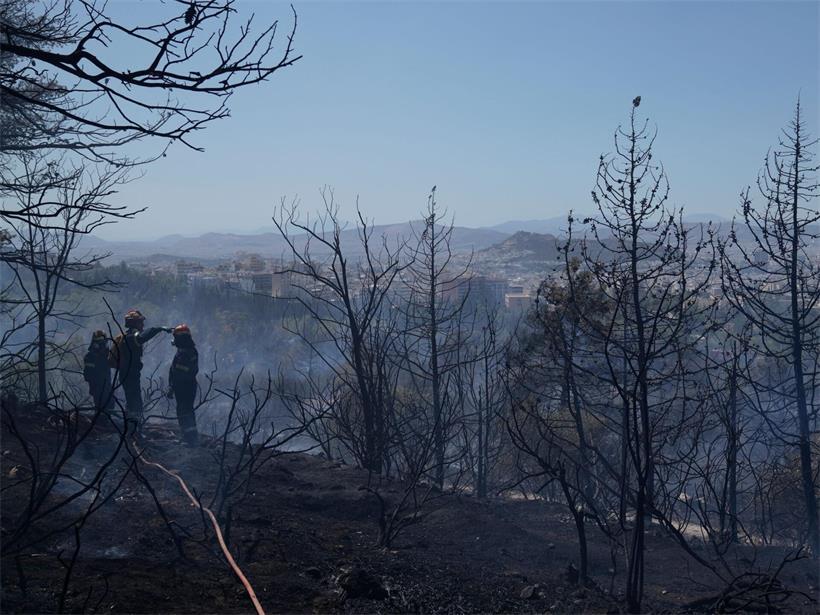 Feuerwehrleute löschen einen Flächenbrand bei Athen