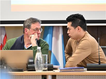 Finanzschöffe Ari Arrensdorff und Bürgermeister Dali Zhu tauschen Blicke im Gemeinderat aus, politische Diskussion live