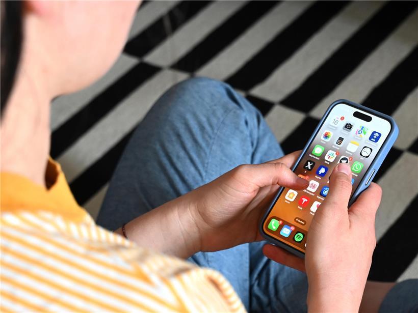 Kind mit Smartphone vor Frankreich-Flagge, Symbol für Verbot sozialer Netzwerke unter 15 Jahren in Frankreich