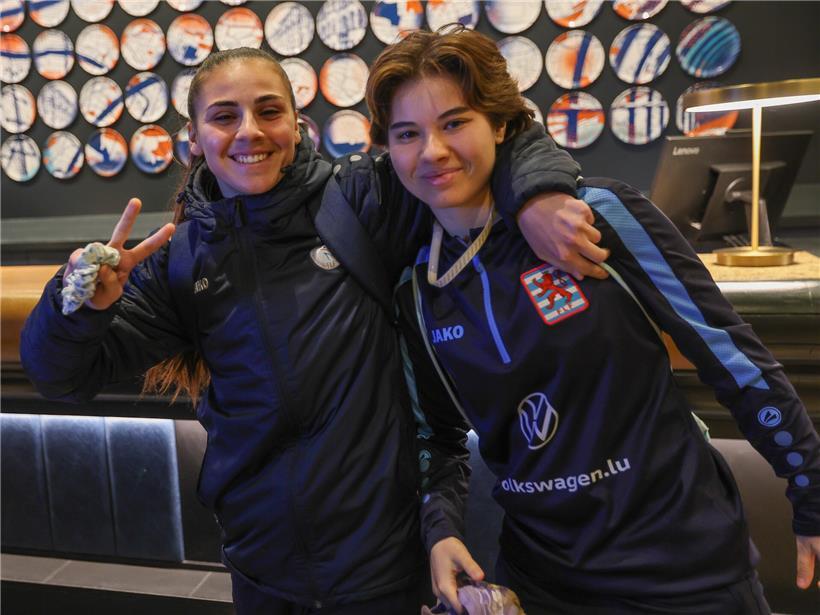 Frau mit strahlendem Lächeln nach dem Training, voller Energie und guter Laune im Fitnessstudio