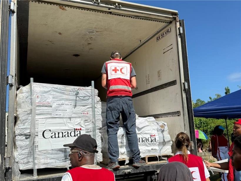 Helfer tragen Hilfspakete vom Lastwagen zur Ausgabestelle für humanitäre Hilfe und Katastrophenhilfe