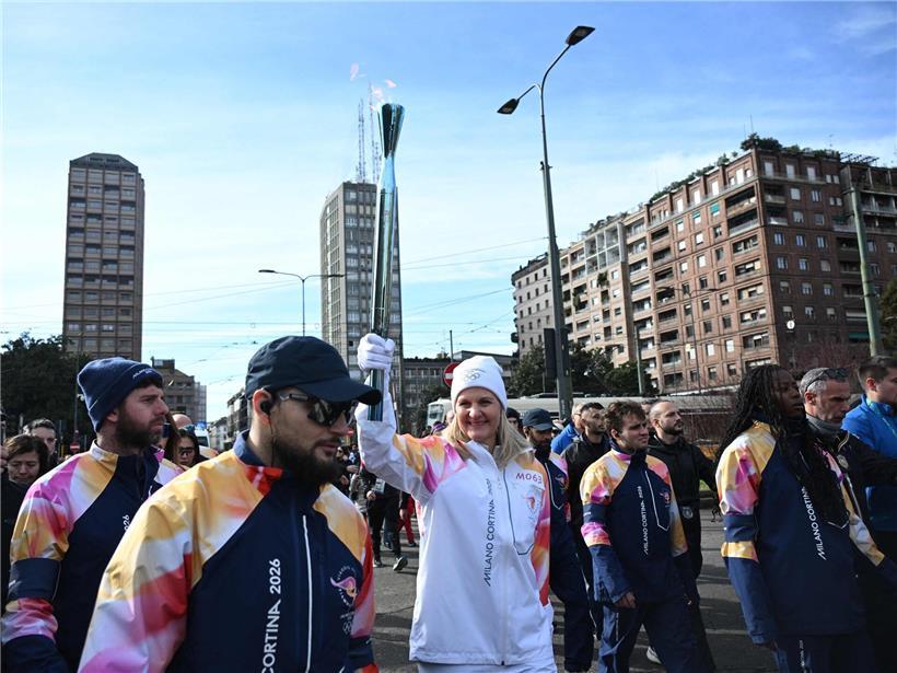 IOC-Präsidentin Kirsten Coventry trägt die olympische Fackel bei der Fackelübergabe in Mailand