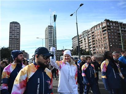 IOC-Präsidentin Kirsten Coventry trägt die olympische Fackel bei der Fackelübergabe in Mailand