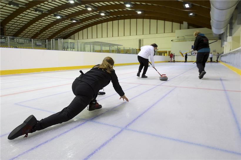 Curling-Spieler mit Stein auf Eisbahn in Luxemburg, symbolisiert 48 aktive Curling-Lizenzen im Land