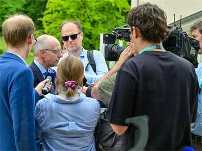 Luxemburgisches Recht auf Informationszugang symbolisiert durch Journalisten, die Politiker zu Transparenz und Pressefreiheit befragen