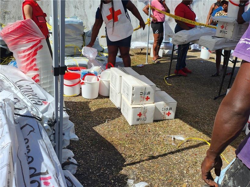 Internationale und lokale Helfer koordinieren gemeinsam die Verteilung von Hilfsgütern vor Ort