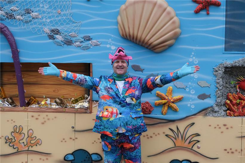 Porträt von Jim Poeckes, gebürtiger „Fuesgeck“, mit freundlichem Lächeln und traditionellem Hintergrund