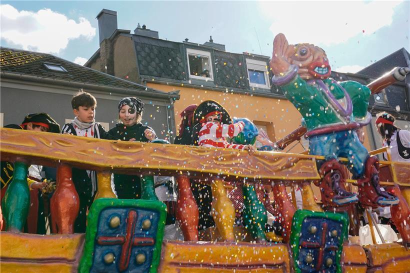 Konfetti fliegt bei der fröhlichen Petinger Kavalkade Parade mit bunten Kostümen und feiernden Menschen