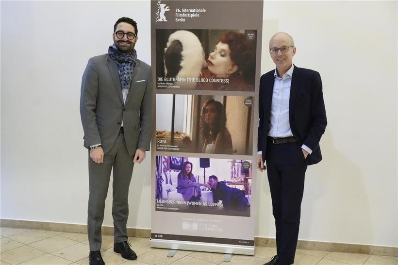 Kulturminister Eric Thill und Premierminister Luc Frieden bei der Berlinale auf rotem Teppich vor Festival-Logo