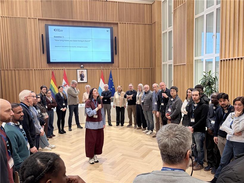 Moderatorin Liz Thielen von Snakke & Co. leitet engagierte Sitzung der Assemblée citoyenne in moderner Konferenzumgebung