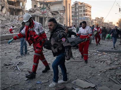 Rettungskräfte tragen nach Luftangriff in Teheran ein Todesopfer weg, Einsatz bei Katastrophenhilfe und Notfallrettung