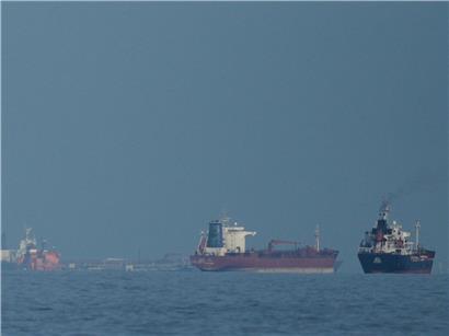 Öltanker und Frachtschiffe warten in der strategischen Straße von Hormus bei klarem Himmel auf ihre Passage