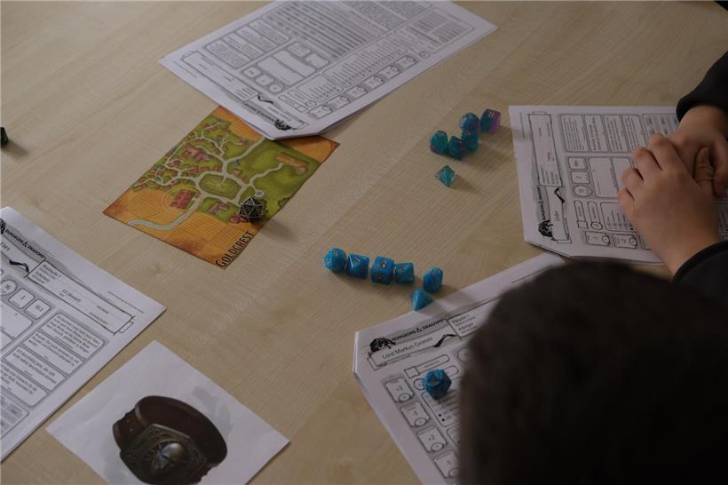 Pen-&-Paper-Rollenspiel ohne Technik zeigt Spieler mit Würfeln, Fokus auf Teamarbeit und Fantasie beim analogen Spiel