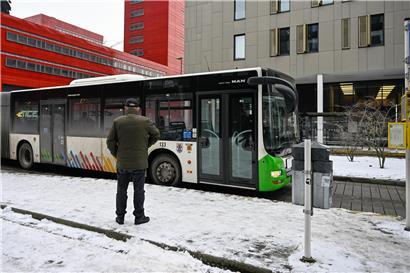 Passagiere im Bus vertieft in Smartphones, Fahrer unbeachtet, moderne Ablenkung im öffentlichen Nahverkehr