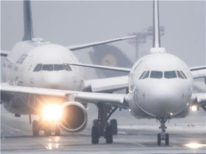 Passagierflugzeuge am Flughafen Frankfurt bei Sprühregen und Schneefall warten auf Startfreigabe
