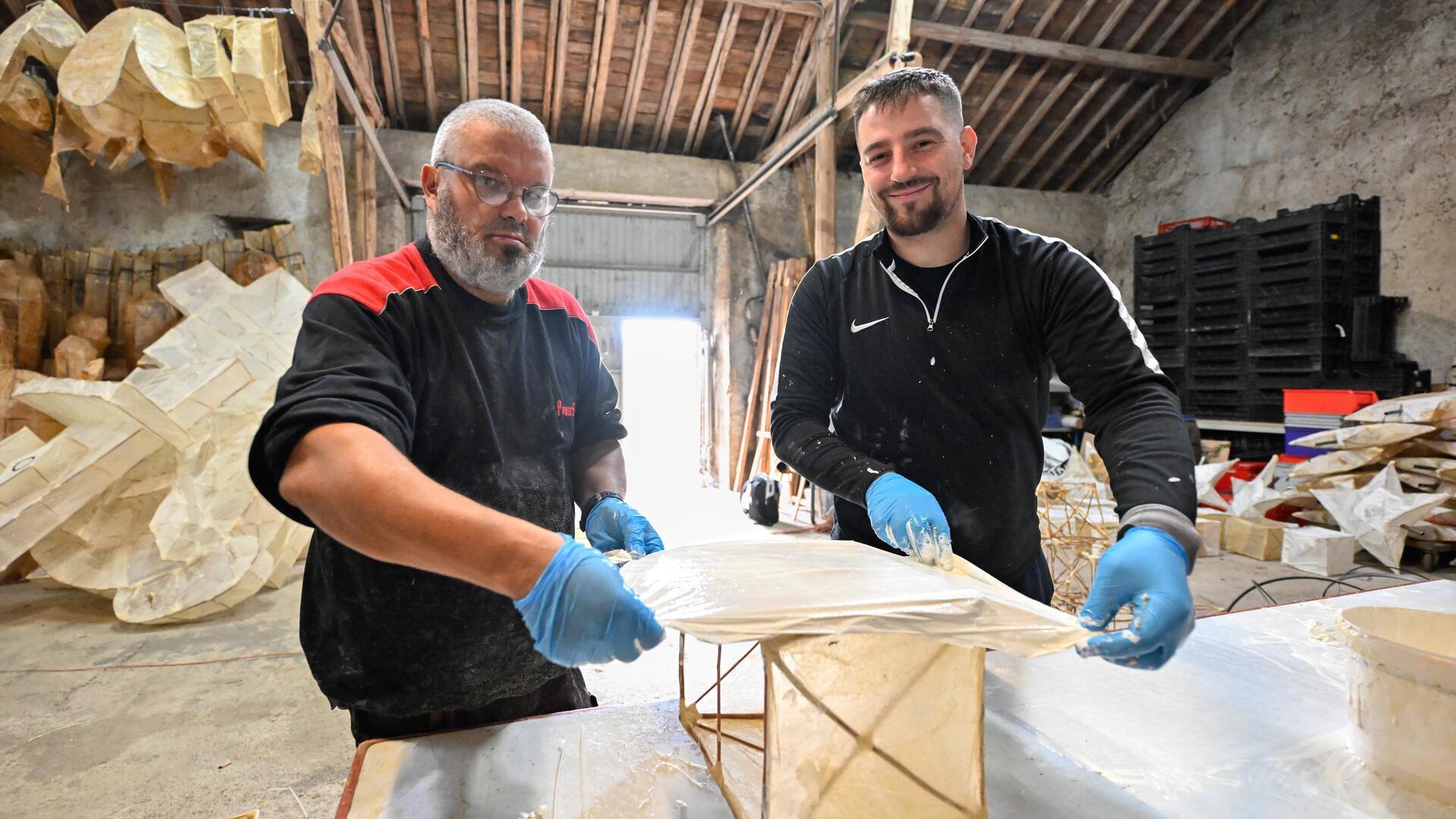 Patrick (53) und Civic (34) beziehen die Bambusgerüste der Lampions mit latexgetränktem Papier