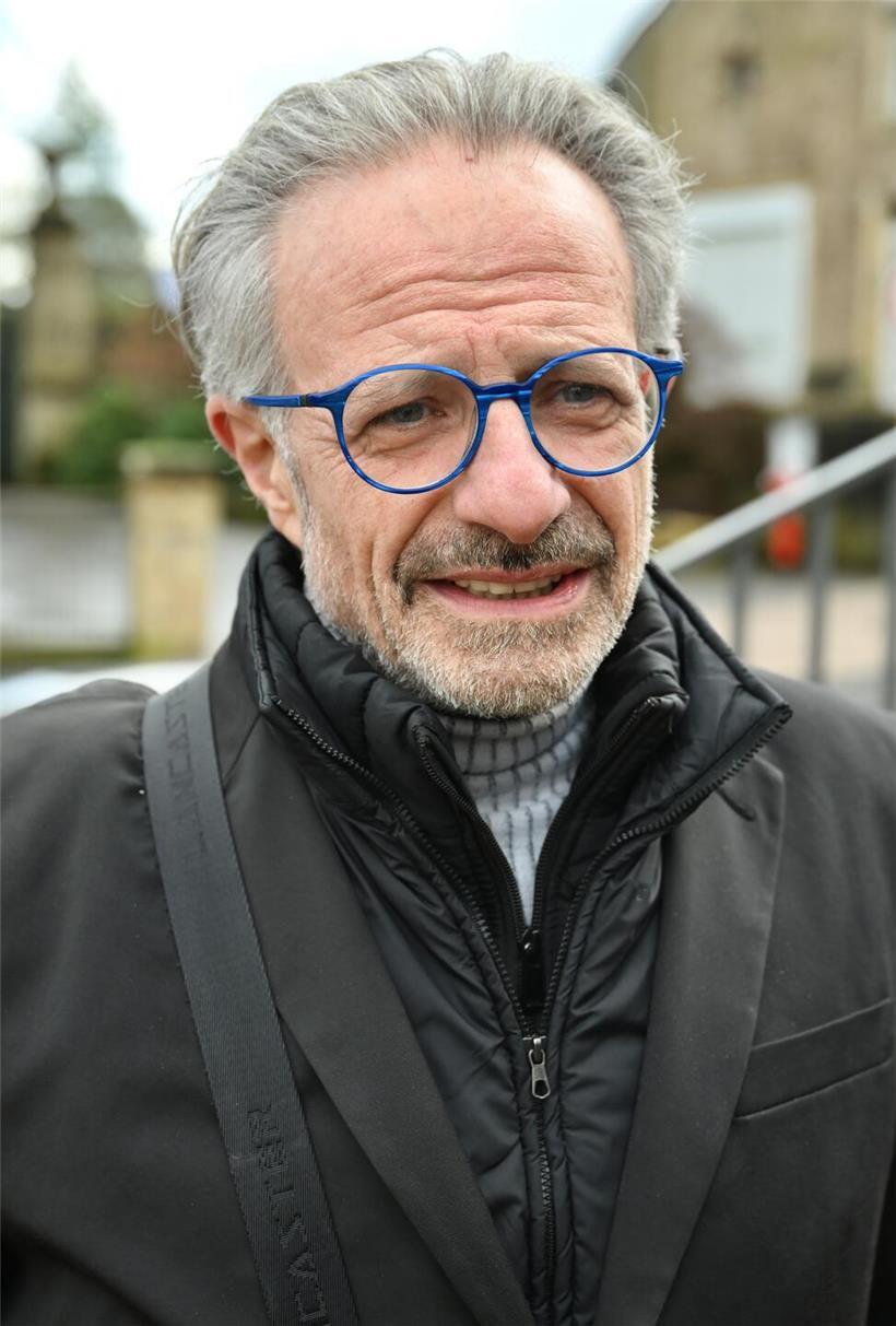 Patrick steht traurig vor dem historischen Rathaus, Symbol für Verlust und Erinnerung in der Stadt.