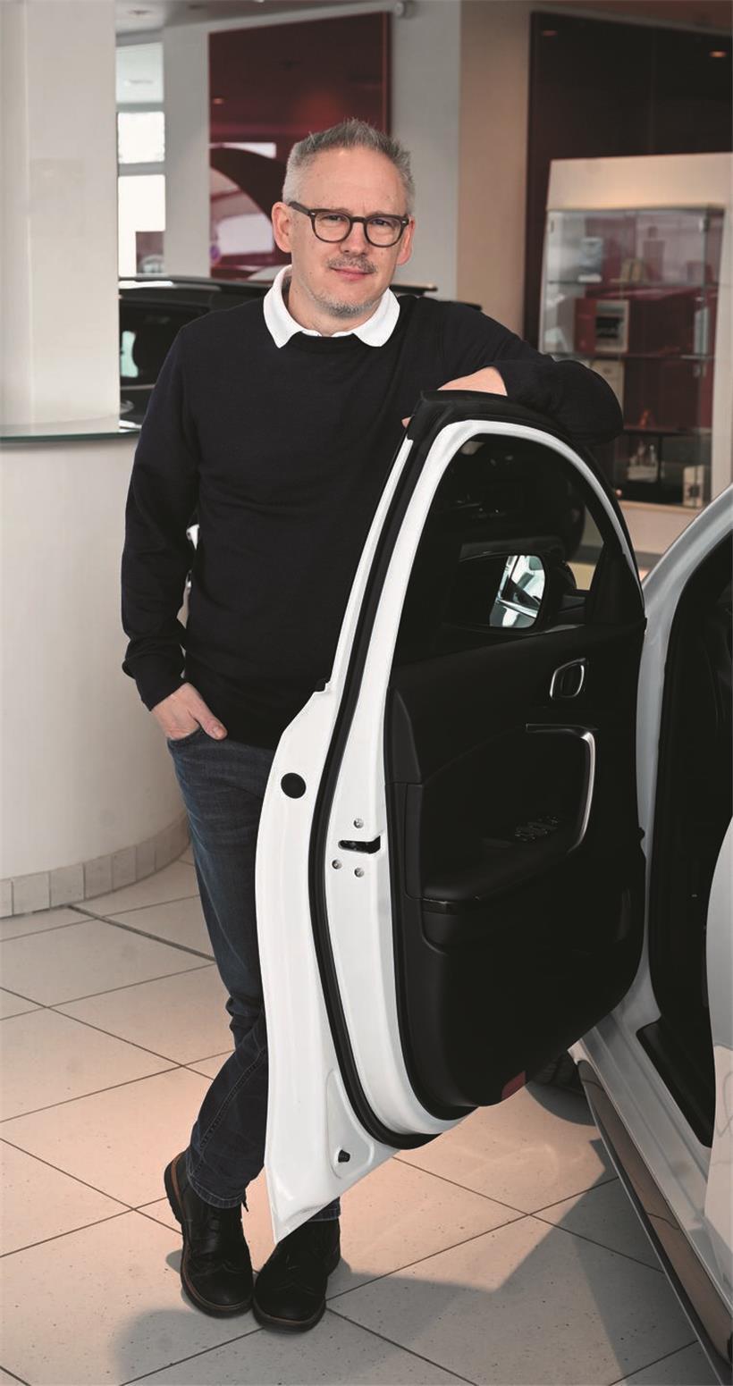 Philippe Mersch lächelt zufrieden beim diesjährigen Autofestival vor einem modernen Sportwagen