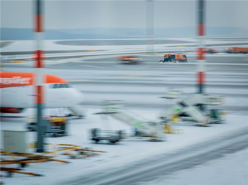 Räumfahrzeuge reinigen verschneite Start- und Landebahnen am Flughafen Berlin Brandenburg BER im Wintereinsatz