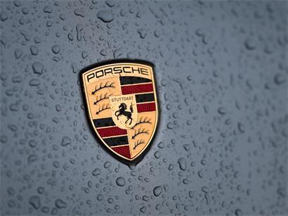 Regentropfen sammeln sich auf einem Porsche Logo