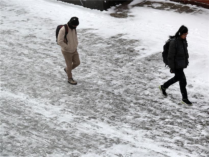 Schneebedeckter Gehweg mit Matsch und Eis, rutschige Winterbedingungen für Fußgänger sicher gehen