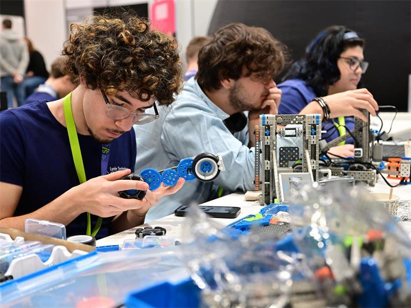 Schüler arbeiten gemeinsam an Technikprojekt, Lernende während Ausbildung in praxisnahem Teamwork