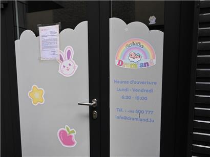 Kinderkleidung hängt zum Trocknen in einer Kita-Garderobe, bunte Jacken und Mützen sichtbar