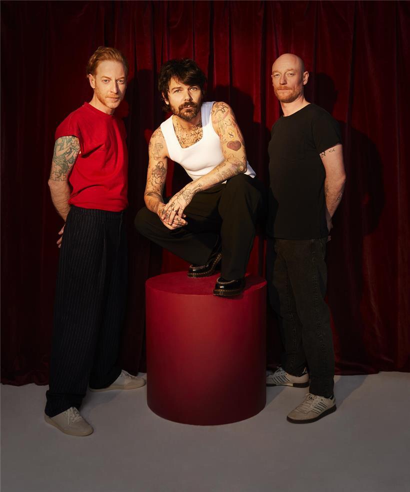 Simon Neil rechts, von Zwillingen James und Ben Johnston als dritter Bruder der Band beschrieben