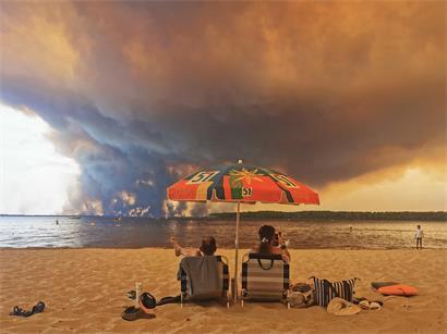 Strandbesucher im Südwesten Frankreichs sehen Rauchwolken von einem Waldbrand in den Himmel aufsteigen