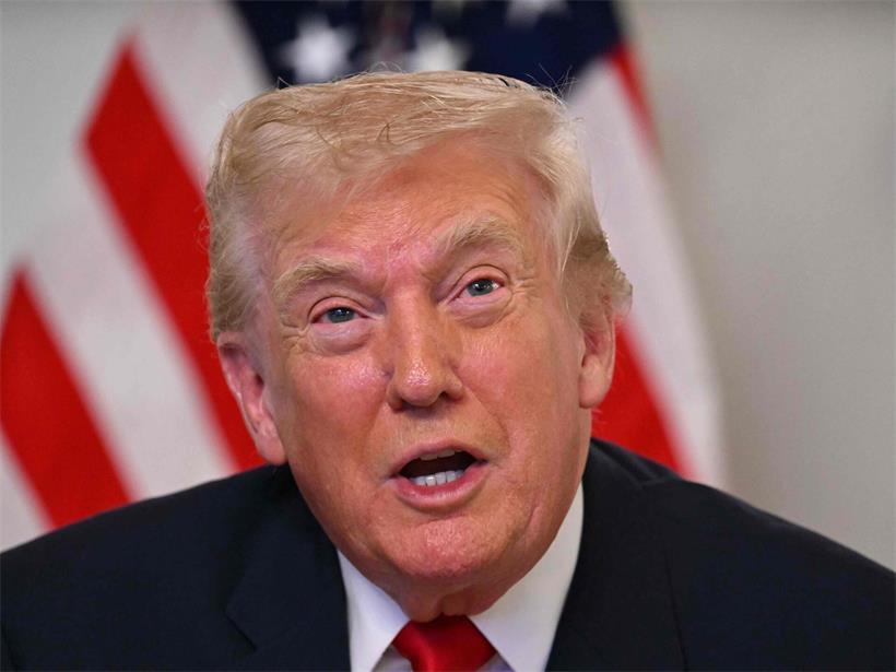 US-Präsident Donald Trump in formellem Anzug bei einer öffentlichen Rede vor amerikanischer Flagge
