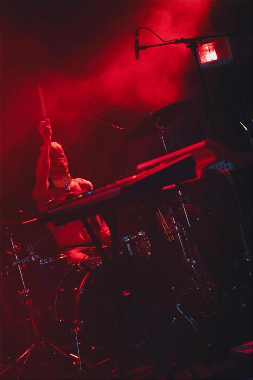 Ein mysteriöses, in dunkle Kleidung gehülltes Gruppenportrait vor nebligem Hintergrund