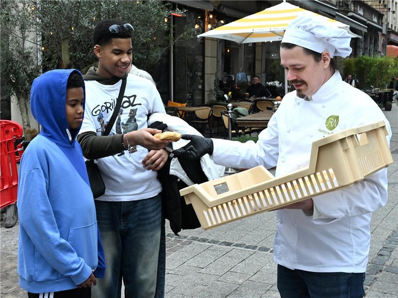 Männer freuen sich am Dienstag über mit Zuckerguss und Mandelblättchen verziertes traditionelles Gebäck