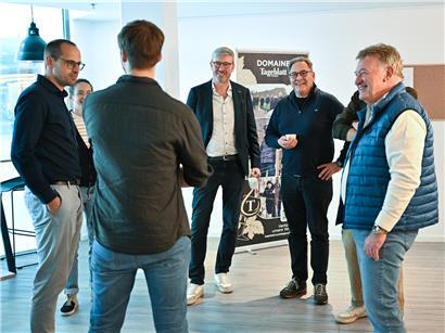 Fünf Gäste arbeiten gemeinsam an einer Zeitungs-Doppelseite während eines Nachmittags-Workshops