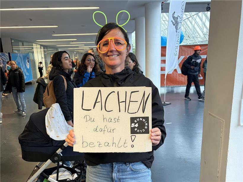 Schlechtes Timing, 1.981 Finisher und kreative Unterstützung Viele kreative Zuschauer halten bunte Anfeuerungsplakate bei einer Sportveranstaltung hoch