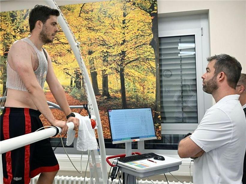 Sportwissenschaftler Eric Besenius misst Herzfrequenz und Belastungsdaten während Leistungstest im Labor