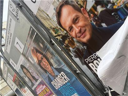 Wahlplakate in Paris an einer Straßenecke mit politischen Botschaften und französischen Flaggen