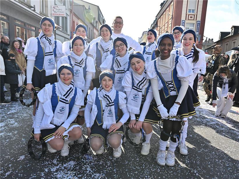 Verkleidete Gruppen beim Karneval in Petingen, Zuschauer auf Tribüne bei farbenfroher Festveranstaltung