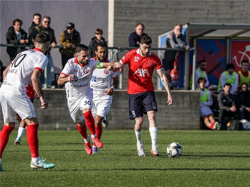 Yannis Bellali in rotem Trikot beim Schließen des Deckels, zeigt schnelle Reaktion und Teamarbeit