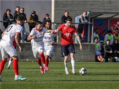 Yannis Bellali in rotem Trikot beim Schließen des Deckels, zeigt schnelle Reaktion und Teamarbeit