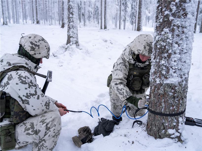 Zwei finnische Soldaten verlegen Anti-Personenminen bei militärischem Manöver im Wald