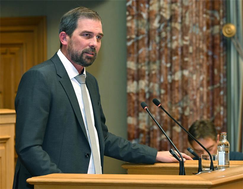 Porträt von Yves Cruchten, zweiter Vize-Präsident der LSAP, in formeller Kleidung vor neutralem Hintergrund