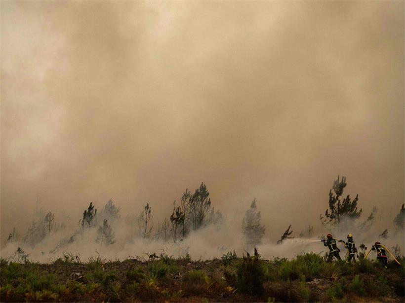 euerwehrleute spritzen bei einem Waldbrand in der Nähe der Stadt Lege-Cap-Feret im Südwesten Frankreichs Wasser
